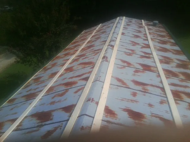 Rusted metal roof panels with new wood purlins before replacement — Storm Damage Roof Repair in White Plains by Roofing Brothers